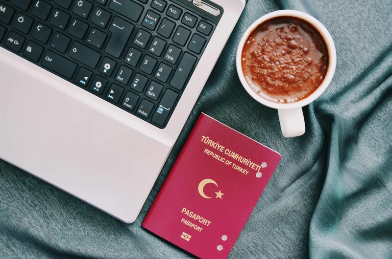 Business registration documents and application forms on a desk with a passport visible