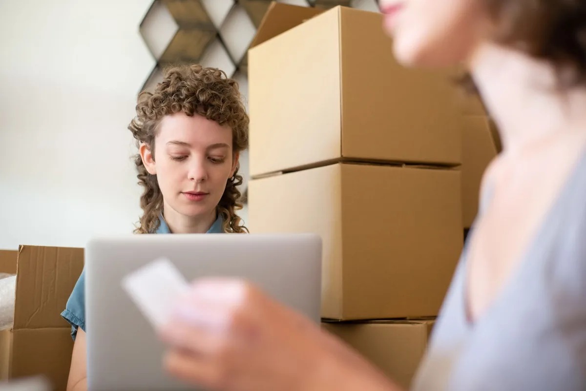 Malaysian online seller reviewing order confirmation records on laptop